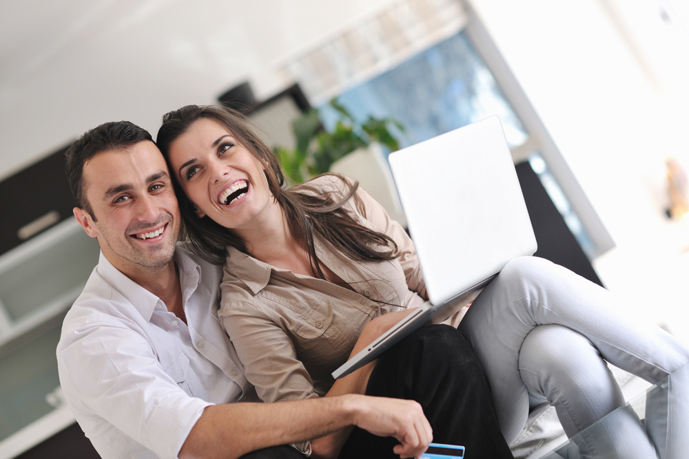 joyful couple relax and work on laptop computer at modern living room indoor home